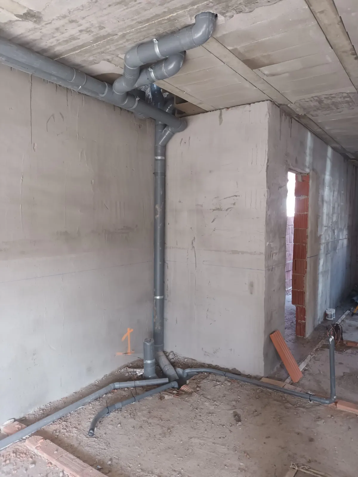 Bajante y colectores de PVC gris de saneamiento en una vivienda en construcción
