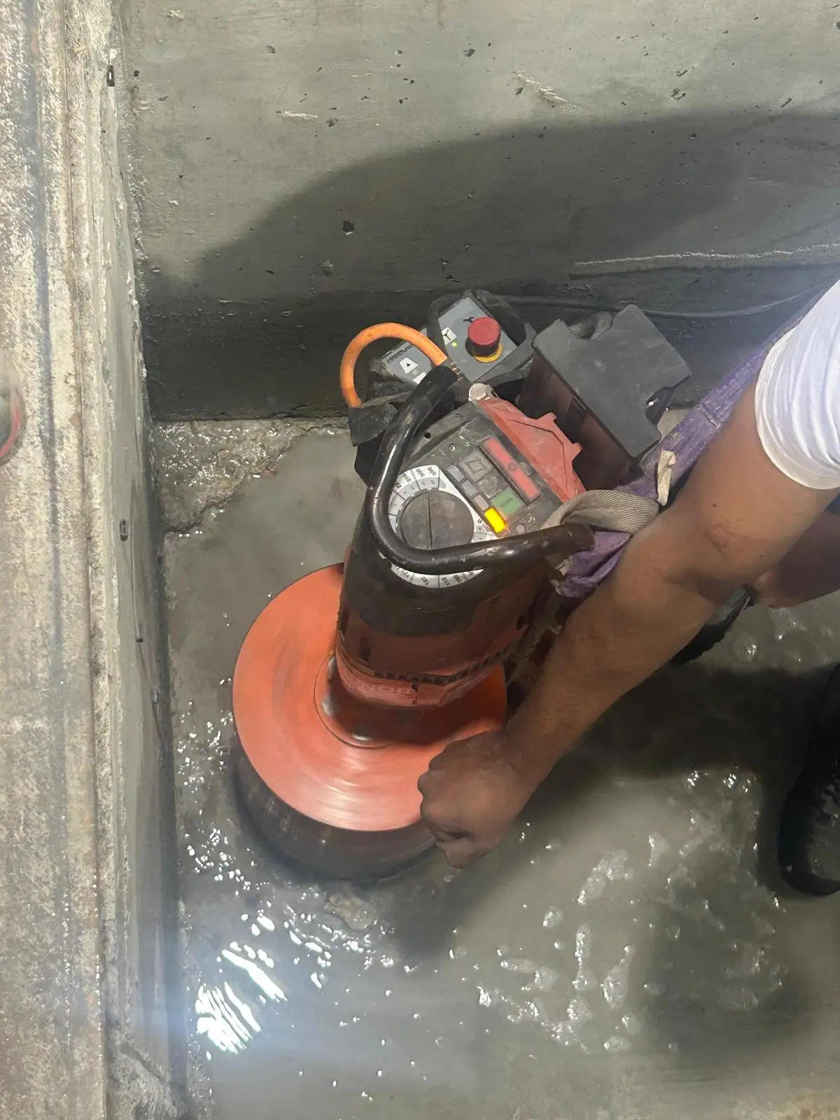 Perforadora con corona de diamante taladrando un suelo de hormigón con agua